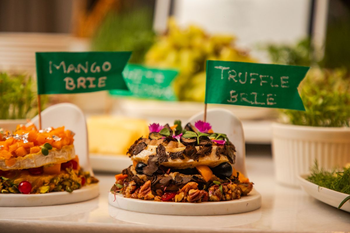 A gourmet display of brie cheese featuring truffle and mango flavors, ideal for culinary presentations.