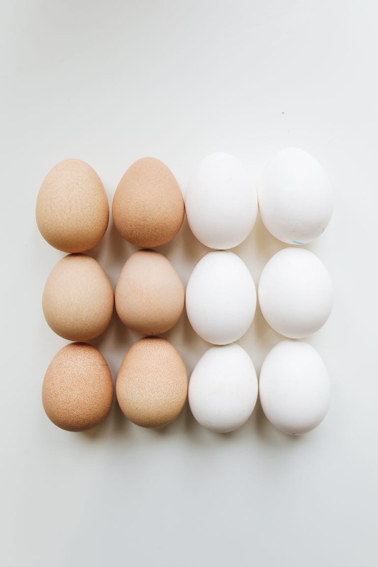 A grid of brown and white eggs on a plain background, showcasing symmetry.
