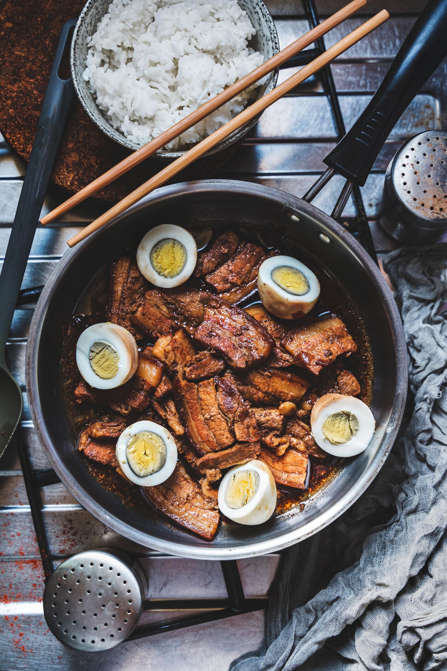 A mouthwatering Filipino adobo dish with pork, eggs, and rice, captured in a warm still life photo.