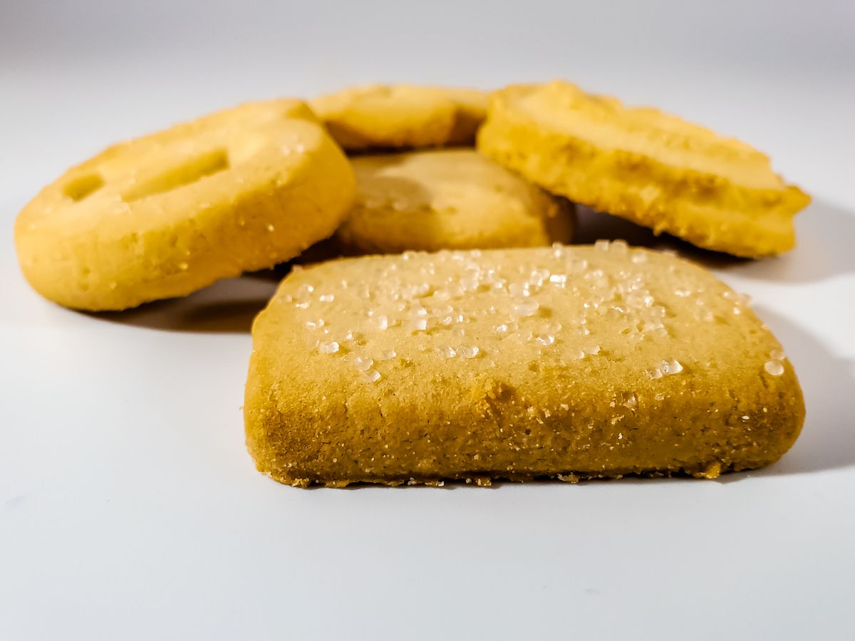 A variety of shortbread cookies with sugar crystals on a white background.