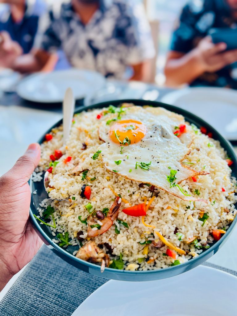 A vibrant plate of fried rice topped with a perfectly cooked egg, perfect for food lovers.