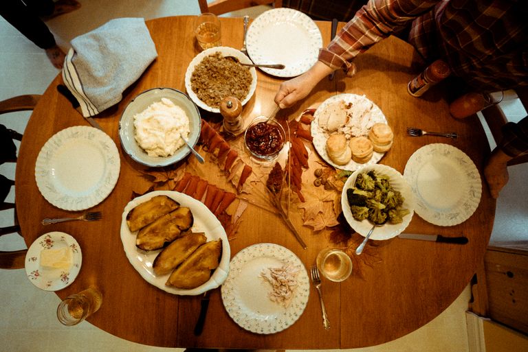 A warm autumn meal with various dishes arranged on a wooden table, perfect for a family gathering.