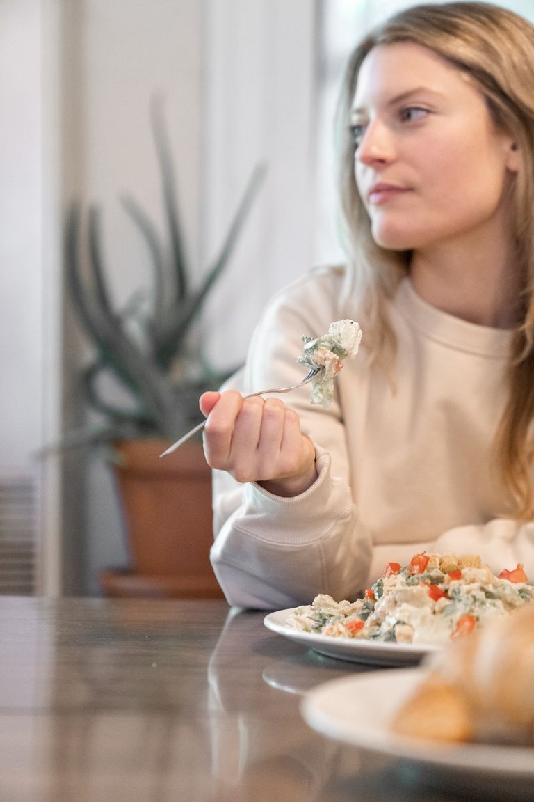 A woman savoring a fresh salad with vegetables, showcasing a healthy lifestyle.