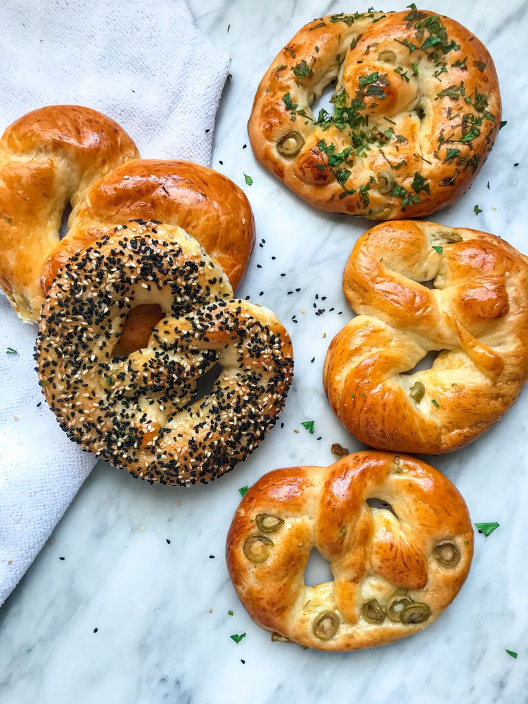 Aerial shot of various freshly baked pretzels on a marble surface, perfect for food photography.