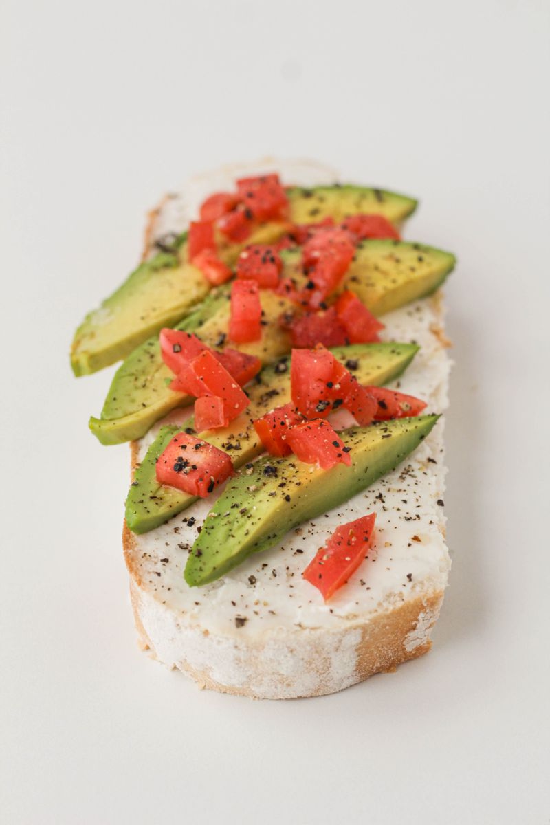 Appetizing avocado toast topped with tomatoes and cheese for a healthy snack.