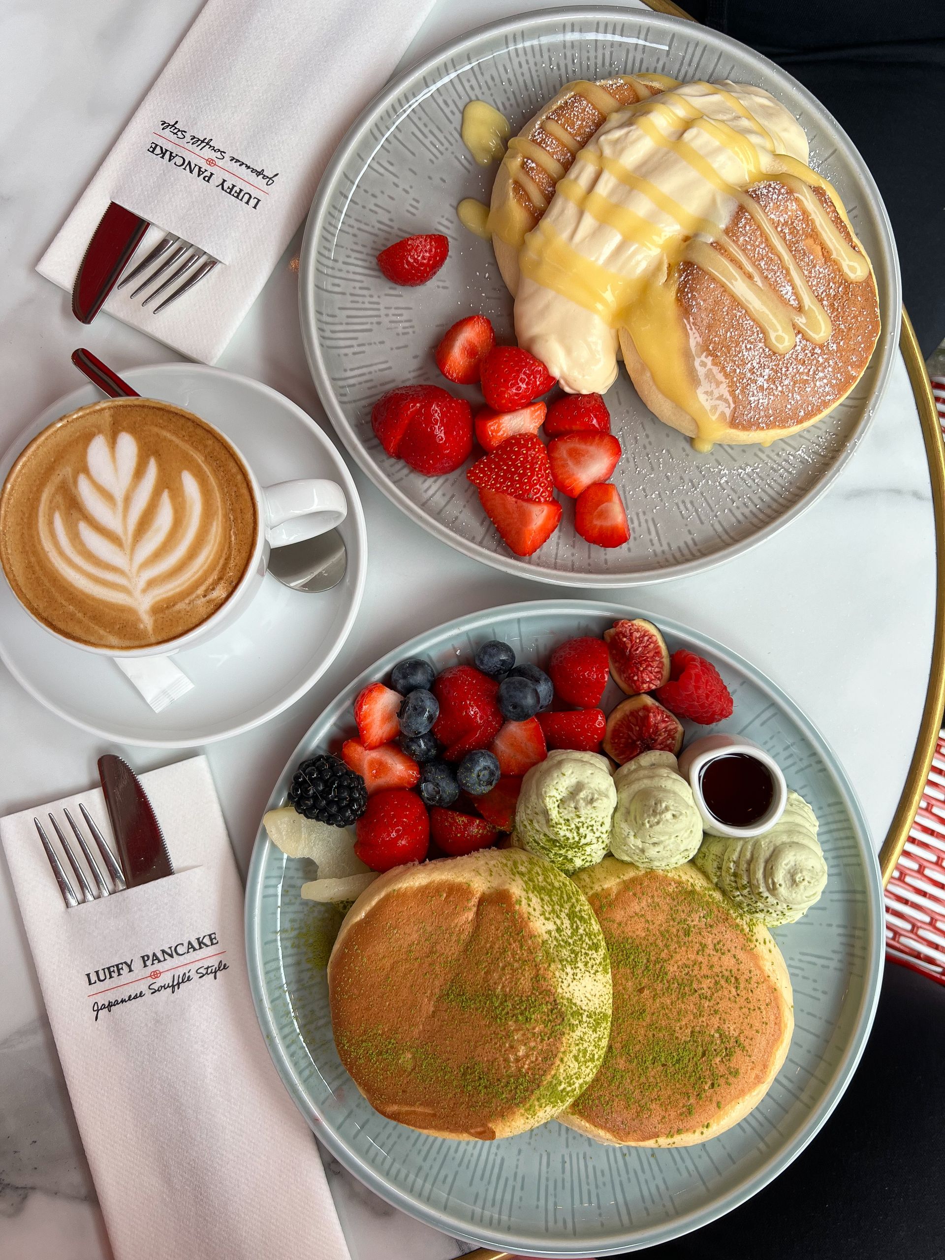 Appetizing pancake breakfast with fresh berries, whipped cream, and coffee.