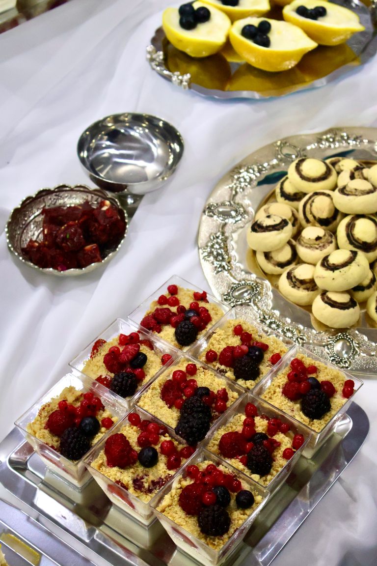 Assorted berry desserts, pastries, and fruit beautifully arranged on silver trays for a festive occasion.