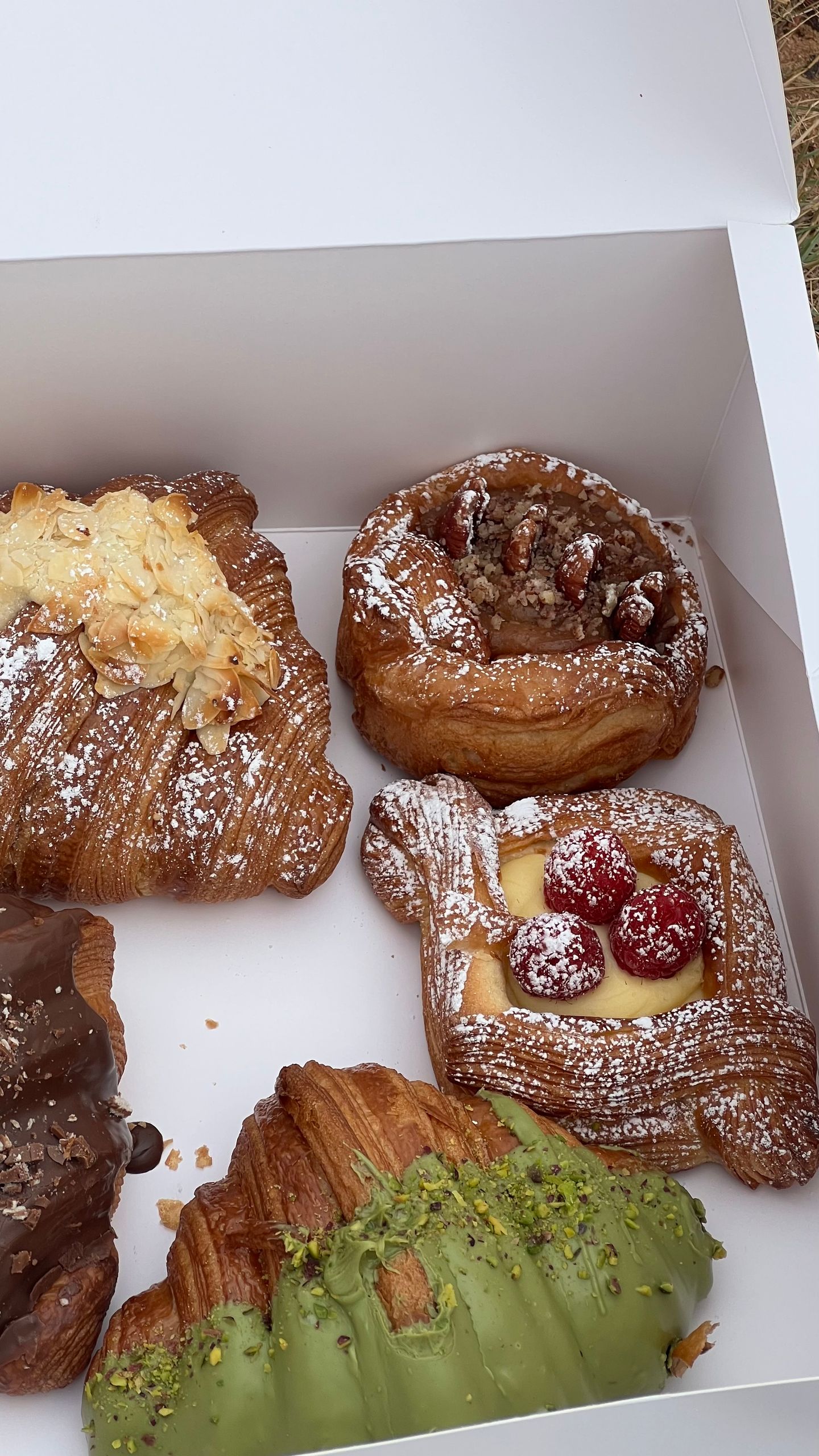 Box of assorted gourmet pastries including croissants and danishes, perfect for breakfast or brunch.