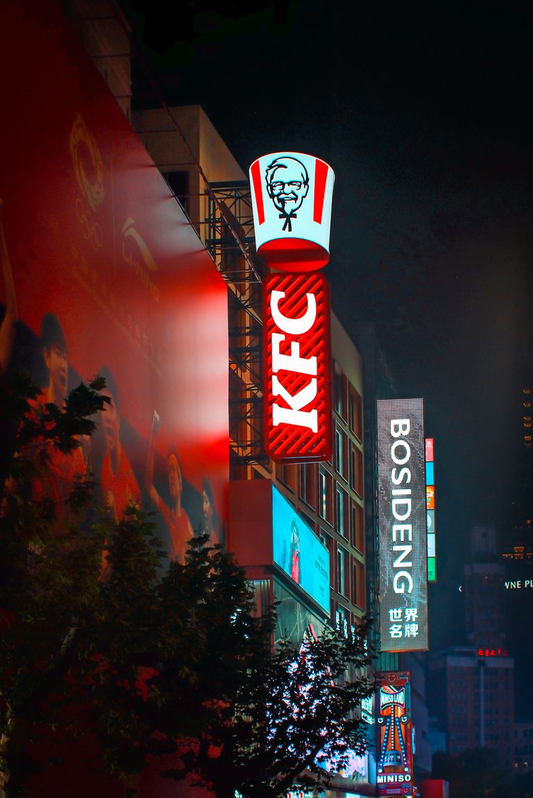 Bright cityscape featuring neon signs of popular brands in an urban night setting.