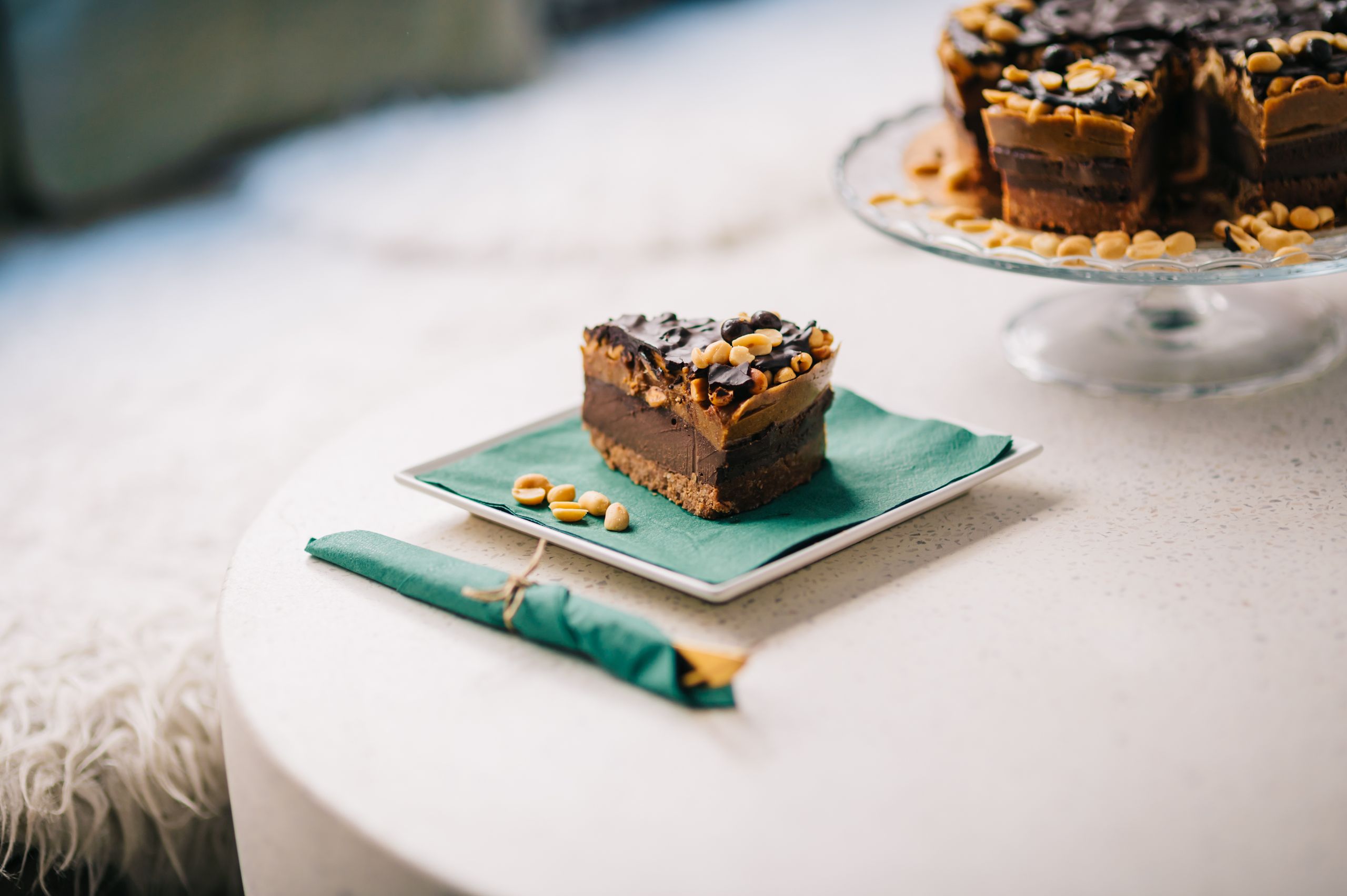 Close-up of a chocolate peanut butter dessert slice on a green napkin.