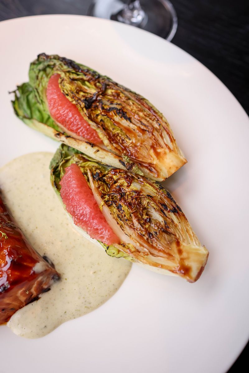 Close-up of grilled romaine lettuce with dressing and balsamic glaze.