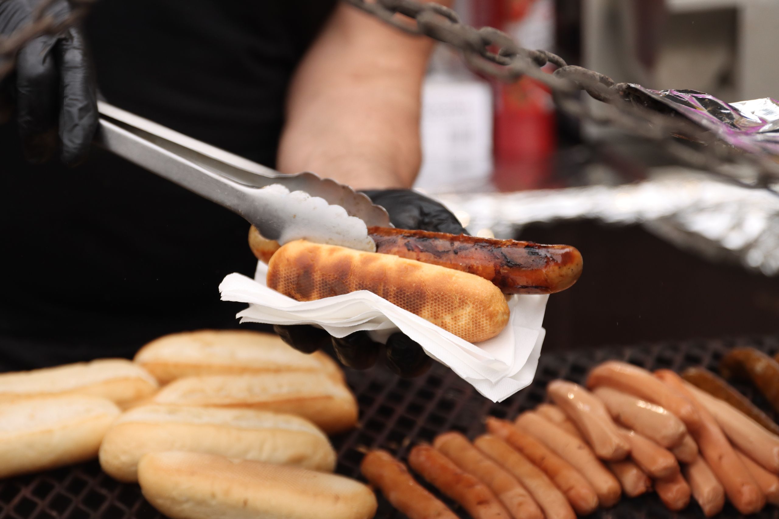 Close-up of grilled sausages being served at a street food stand in Jönköping, Sweden.