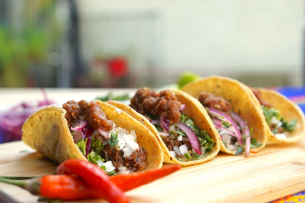 Close-up of tasty beef tacos with onions and cilantro, perfect for Mexican cuisine lovers.
