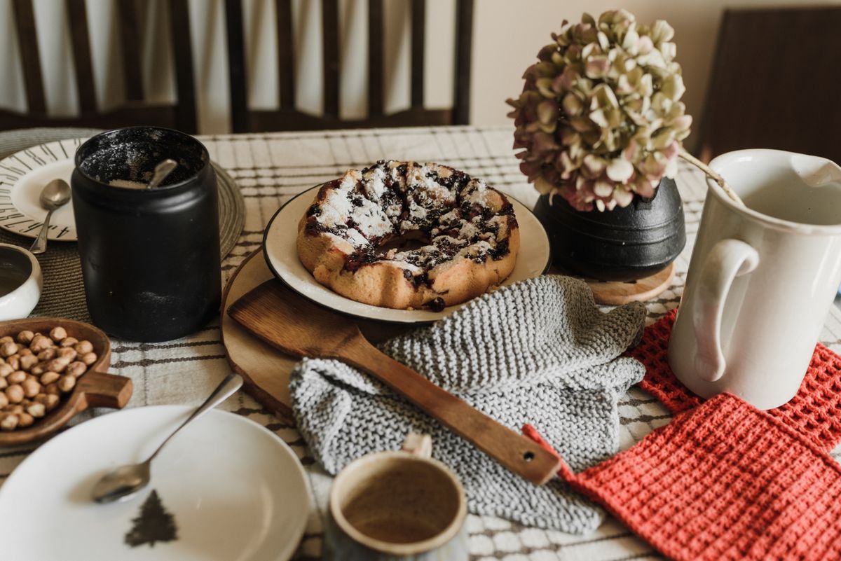 Cozy morning setup with a homemade pastry, coffee, and rustic decor on a wooden table.
