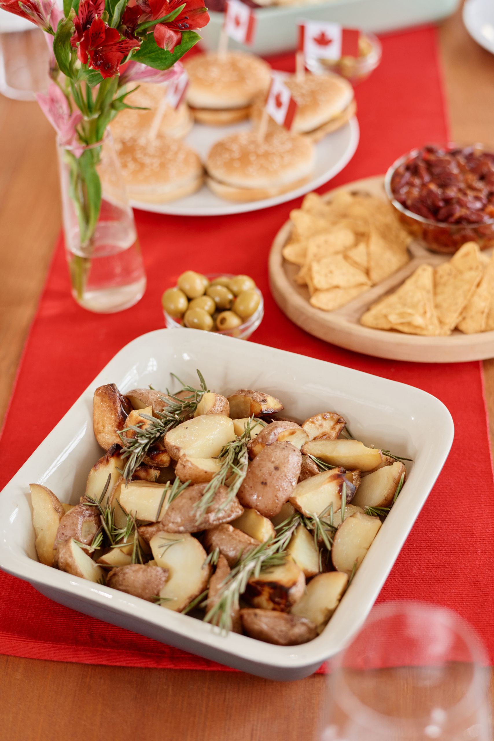 Delicious baked potatoes and snacks on a festive table with Canadian flags, perfect for a celebration.