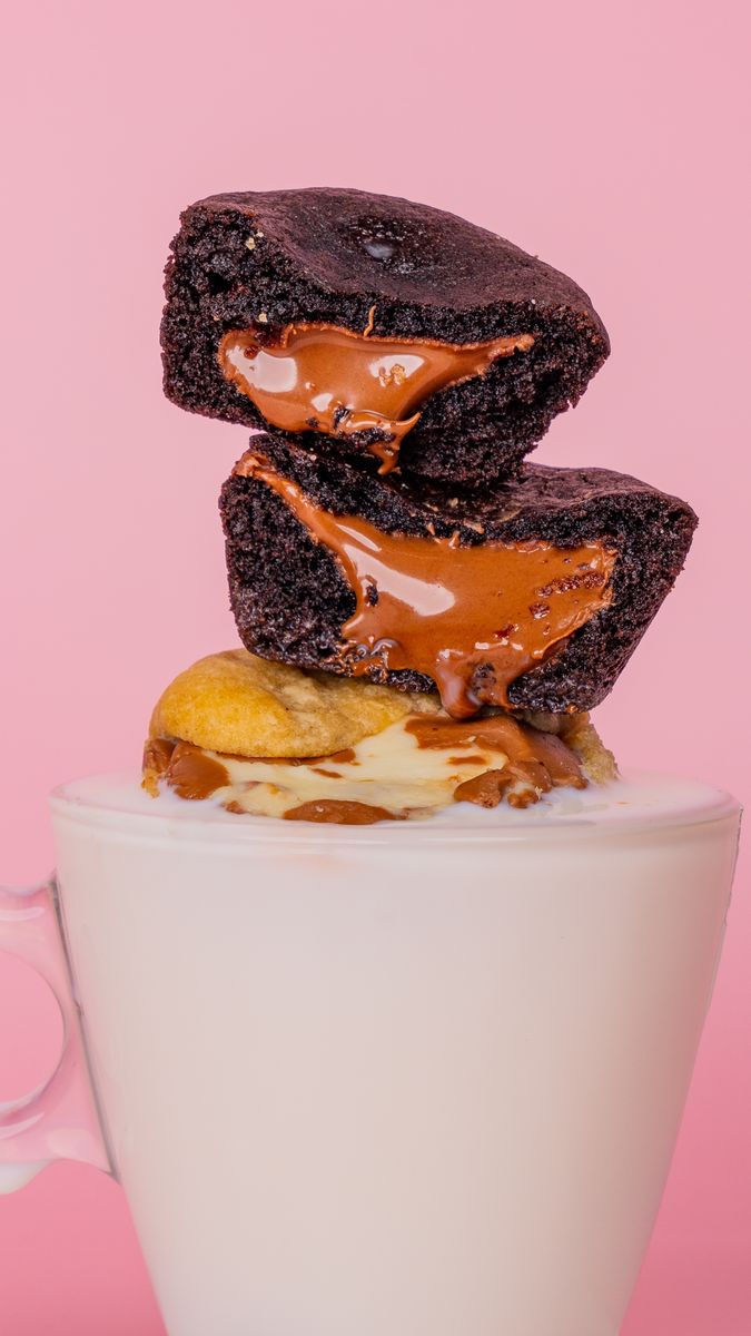 Delicious chocolate brownies stacked on a cup with a pink background for tempting food photography.