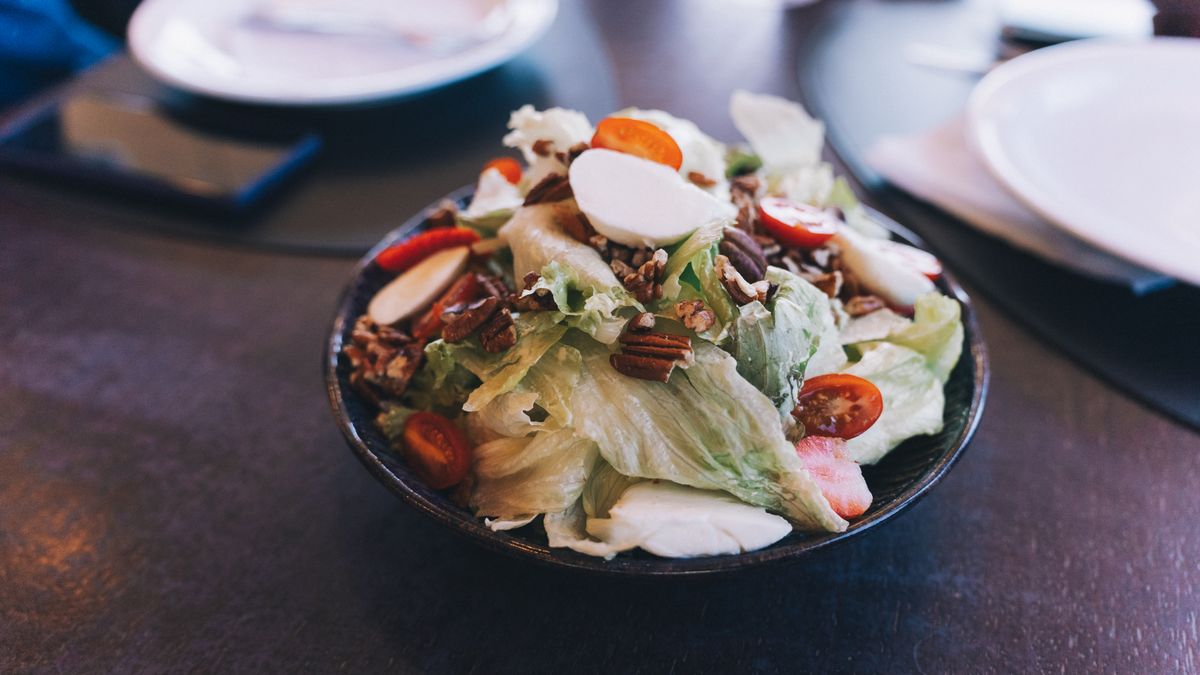 Delicious fresh salad with cherry tomatoes, nuts, and mozzarella in a bowl.