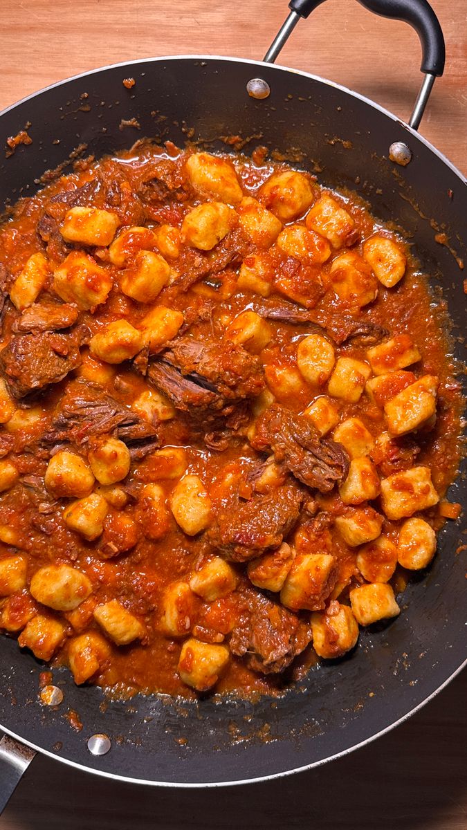 Delicious gnocchi cooked with rich tomato and beef sauce served in a large skillet.