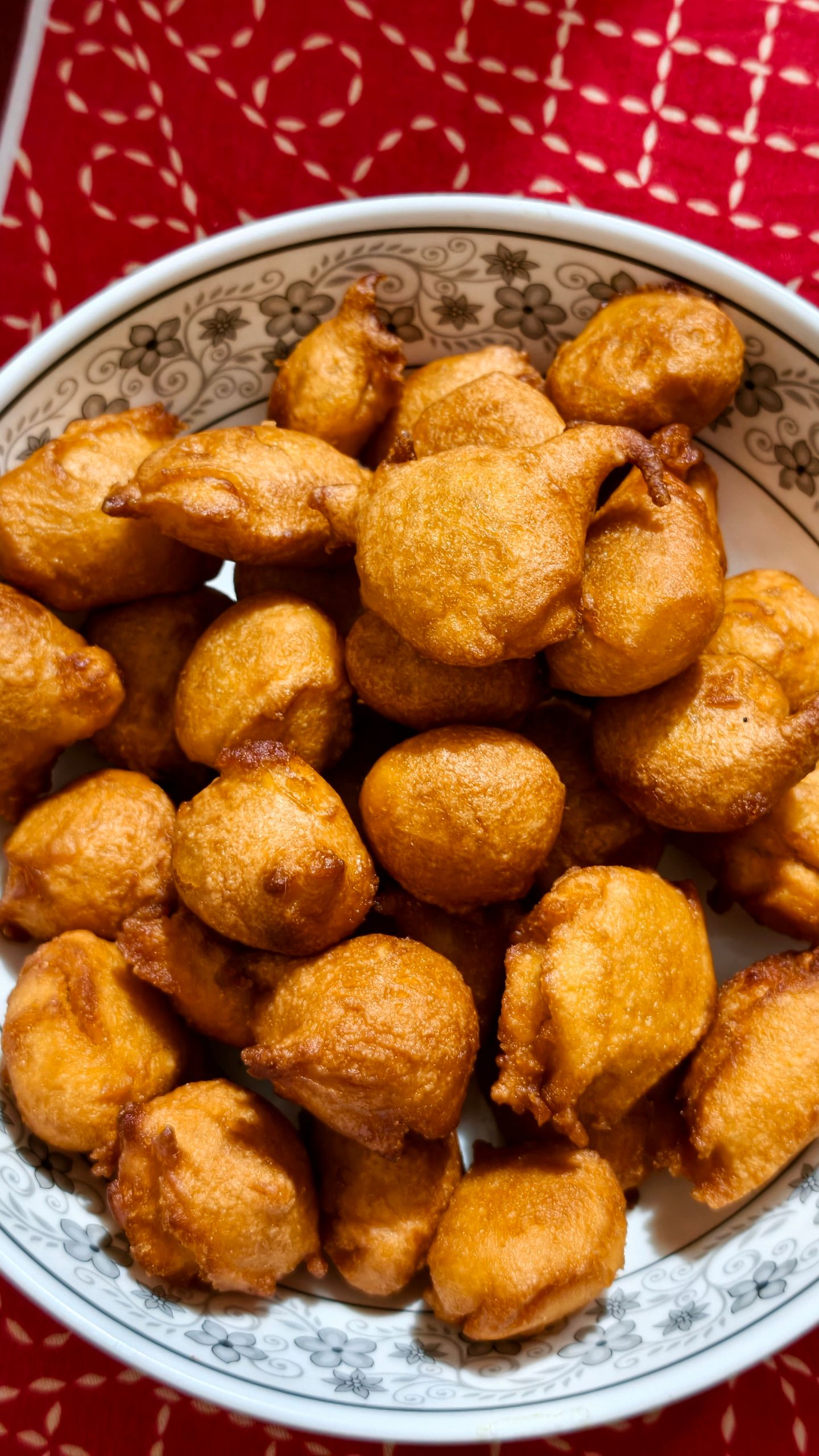 Delicious golden brown fried snacks in a traditional patterned bowl.