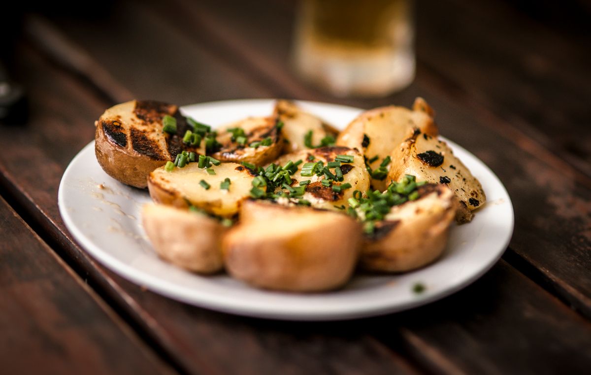 Delicious grilled potatoes garnished with fresh chives, perfect for a rustic meal.