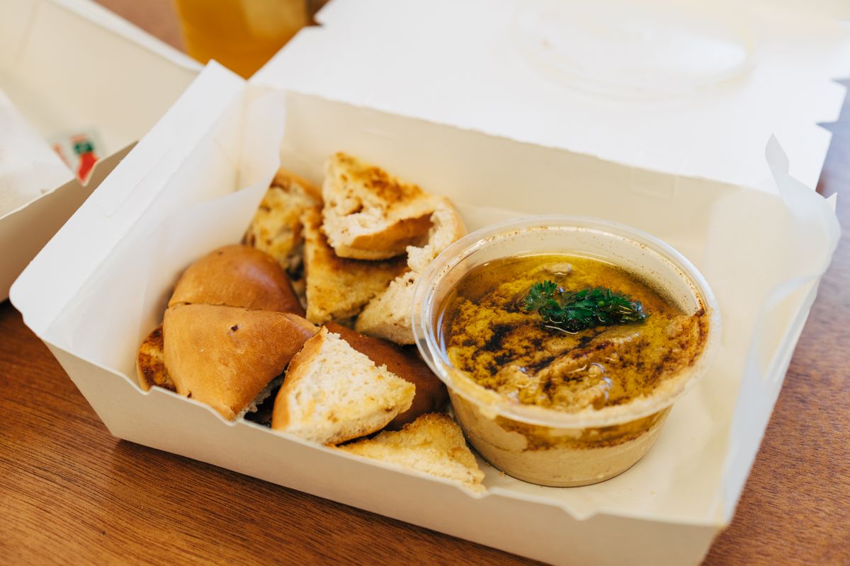 Delicious hummus served with assorted bread in a takeout box, shot in Singapore.