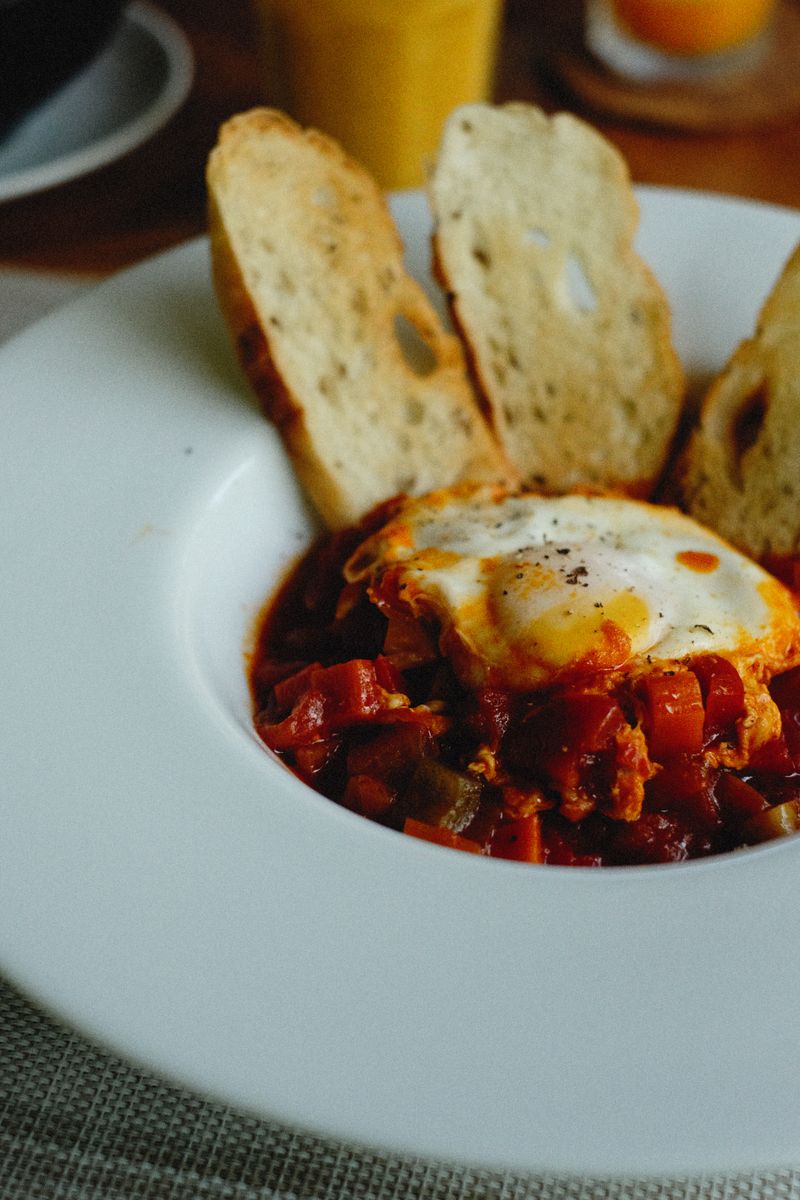 Delicious shakshuka served with crispy bread, perfect for a hearty breakfast or brunch.
