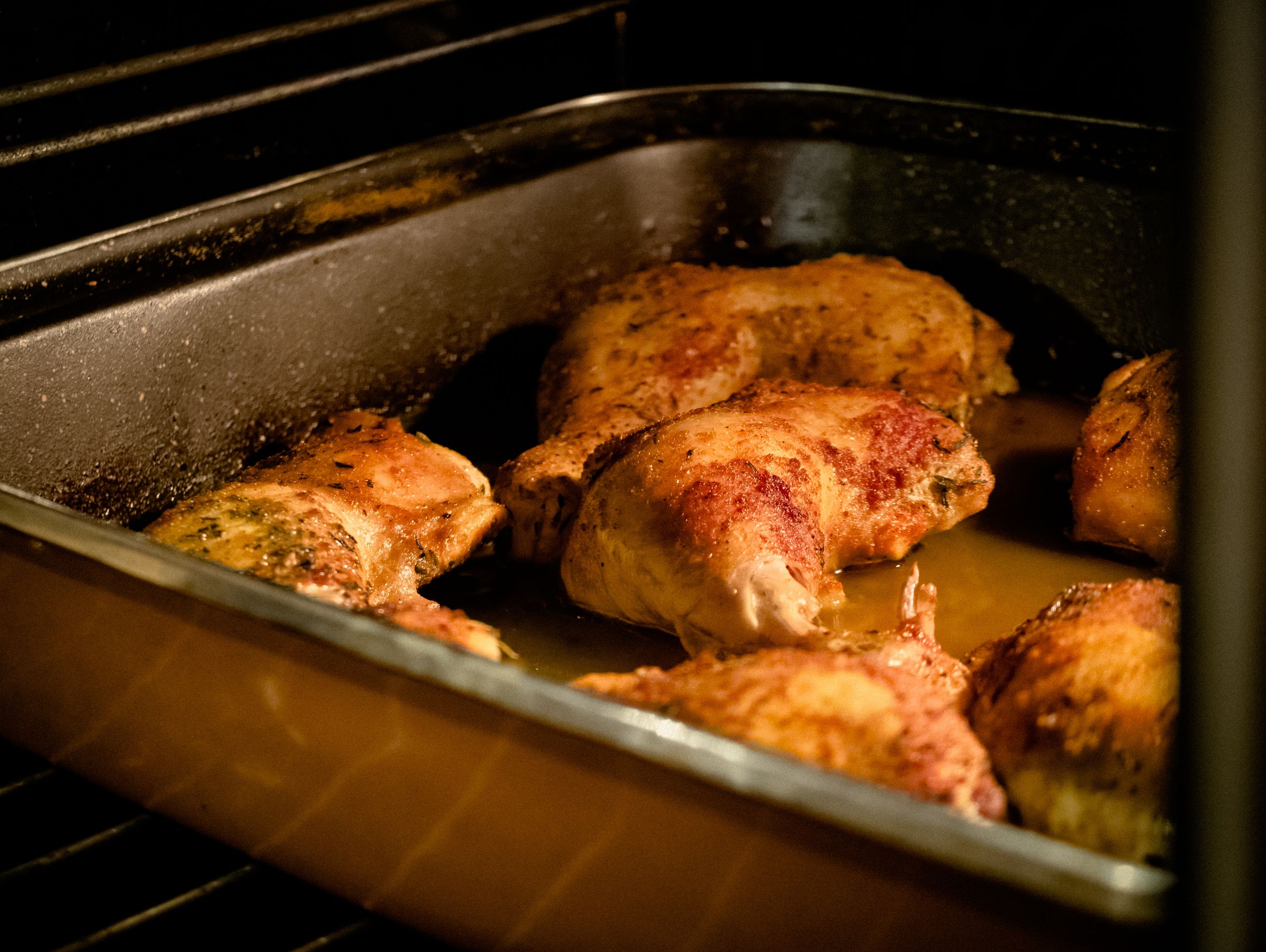 Deliciously seasoned chicken legs roasting in an oven for a home-cooked meal.