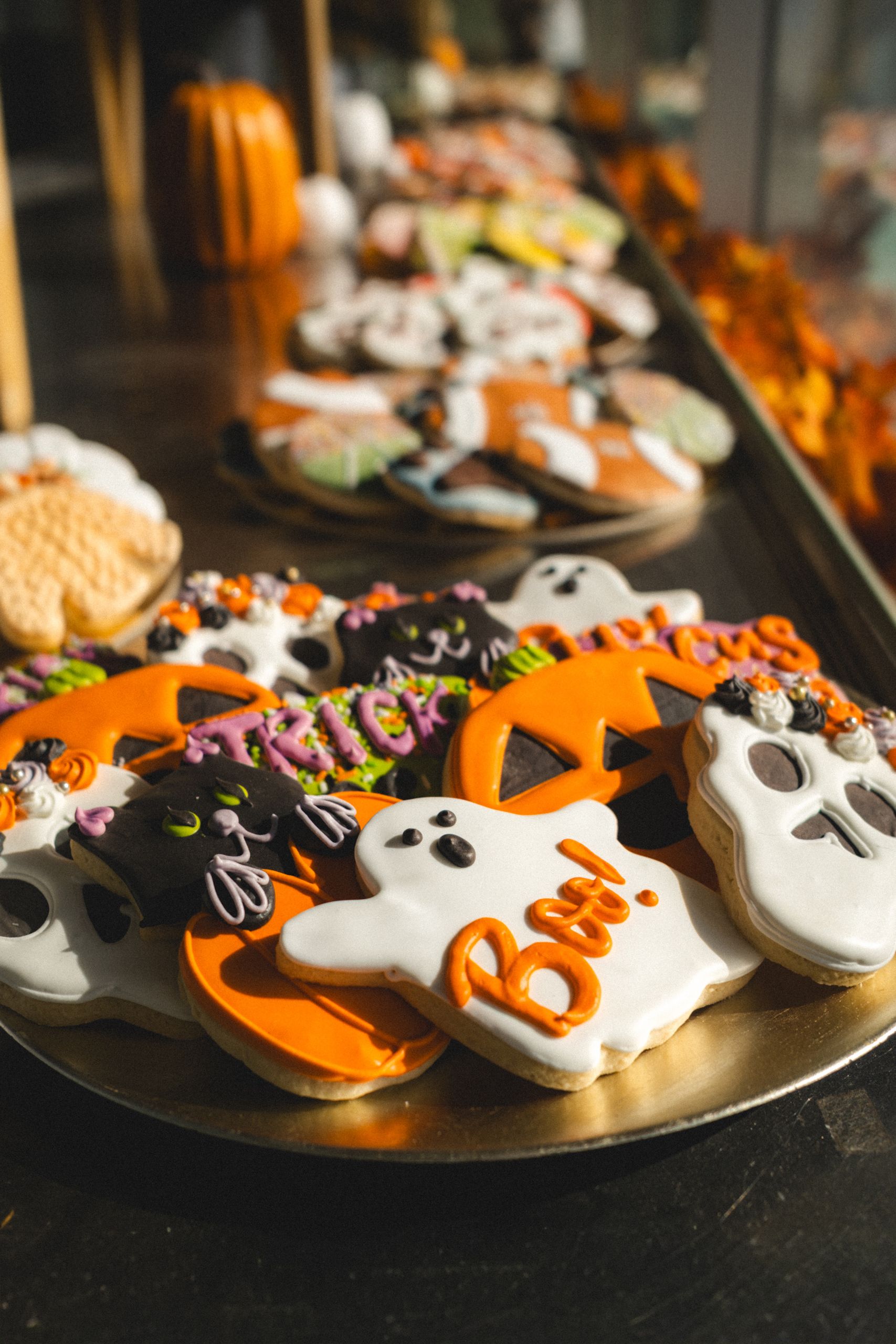 Festive Halloween cookies with ghost, pumpkin, and 'Boo!' decorations on a tray.