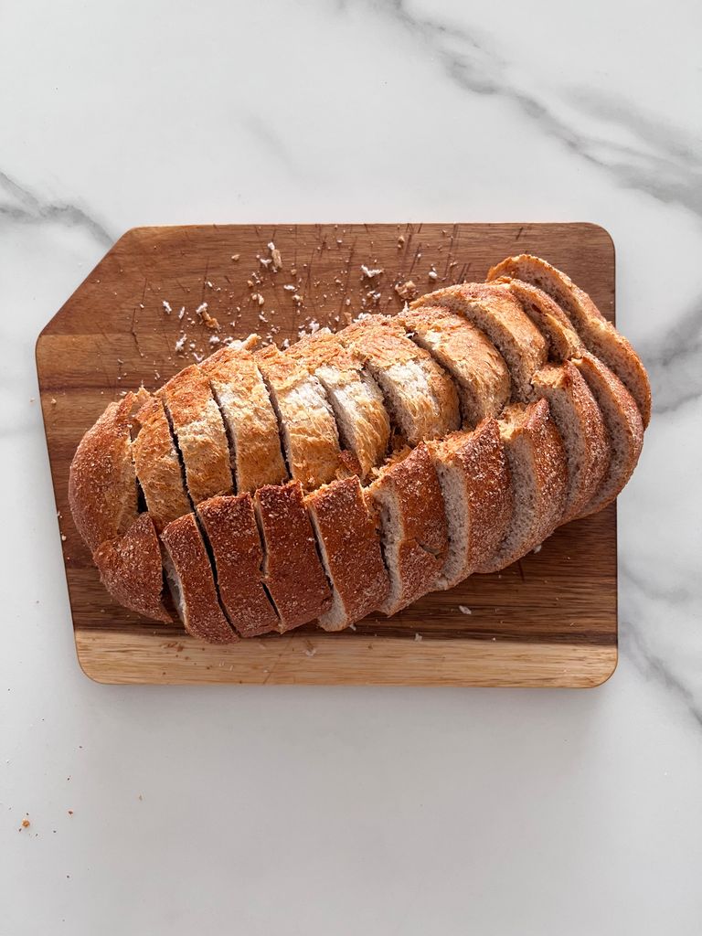 Freshly sliced artisanal bread on a cutting board, perfect for breakfast or a snack.