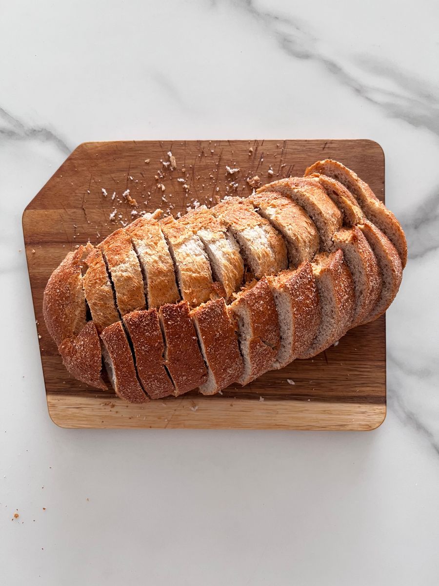 Freshly sliced artisanal bread on a cutting board, perfect for breakfast or a snack.