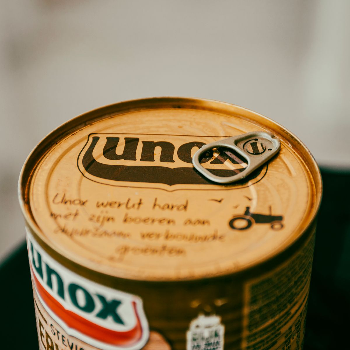 High-quality image of a Unox product can showcasing branding and pull tab in warm tones.