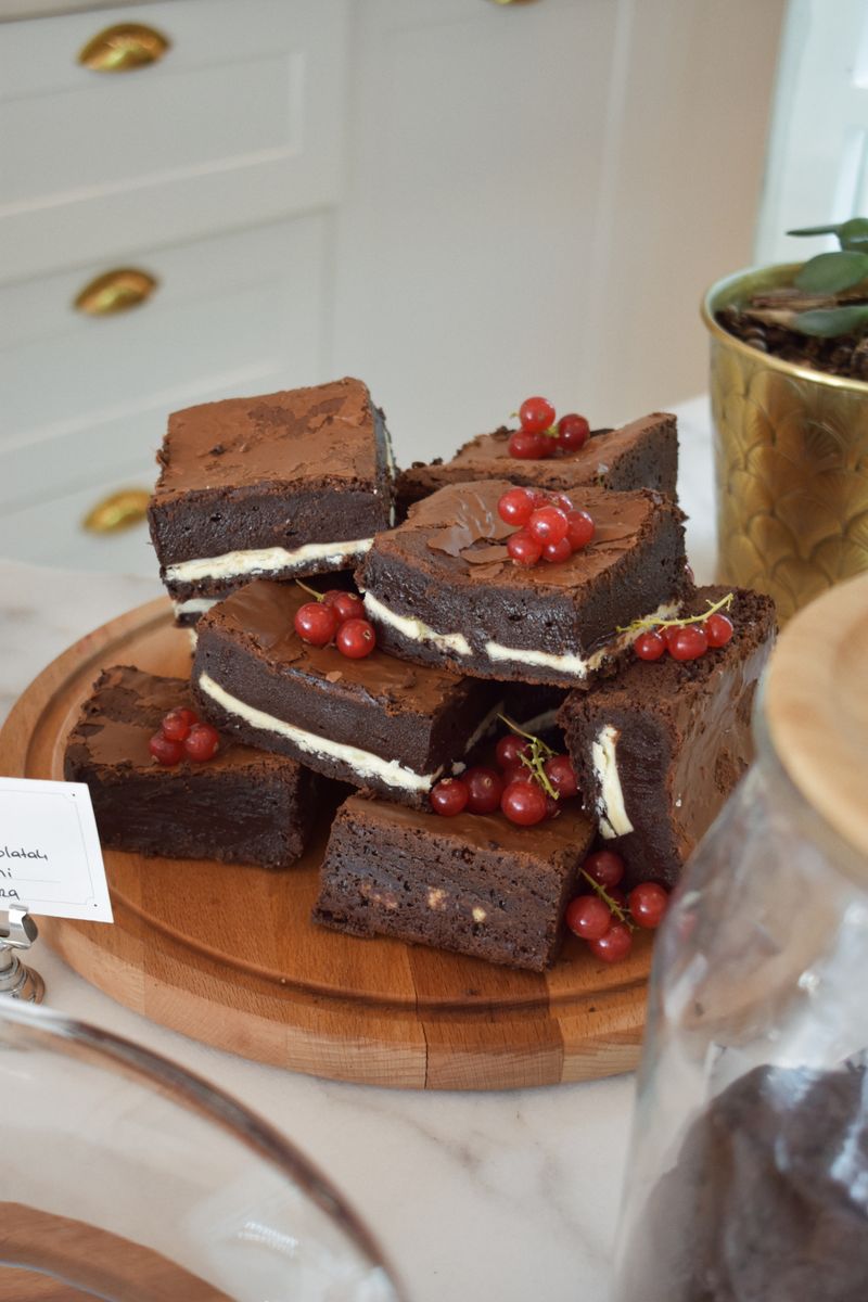 Indulge in homemade chocolate brownies, topped with fresh red berries, on a wooden board.