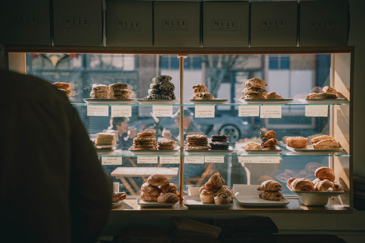 Inviting bakery display with assorted pastries and desserts capturing the warm ambiance of a cozy caf&eacute;.