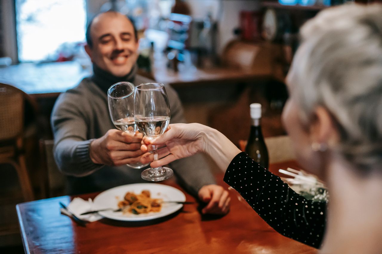 happy-couple-clinking-wineglasses-in-restaurant-