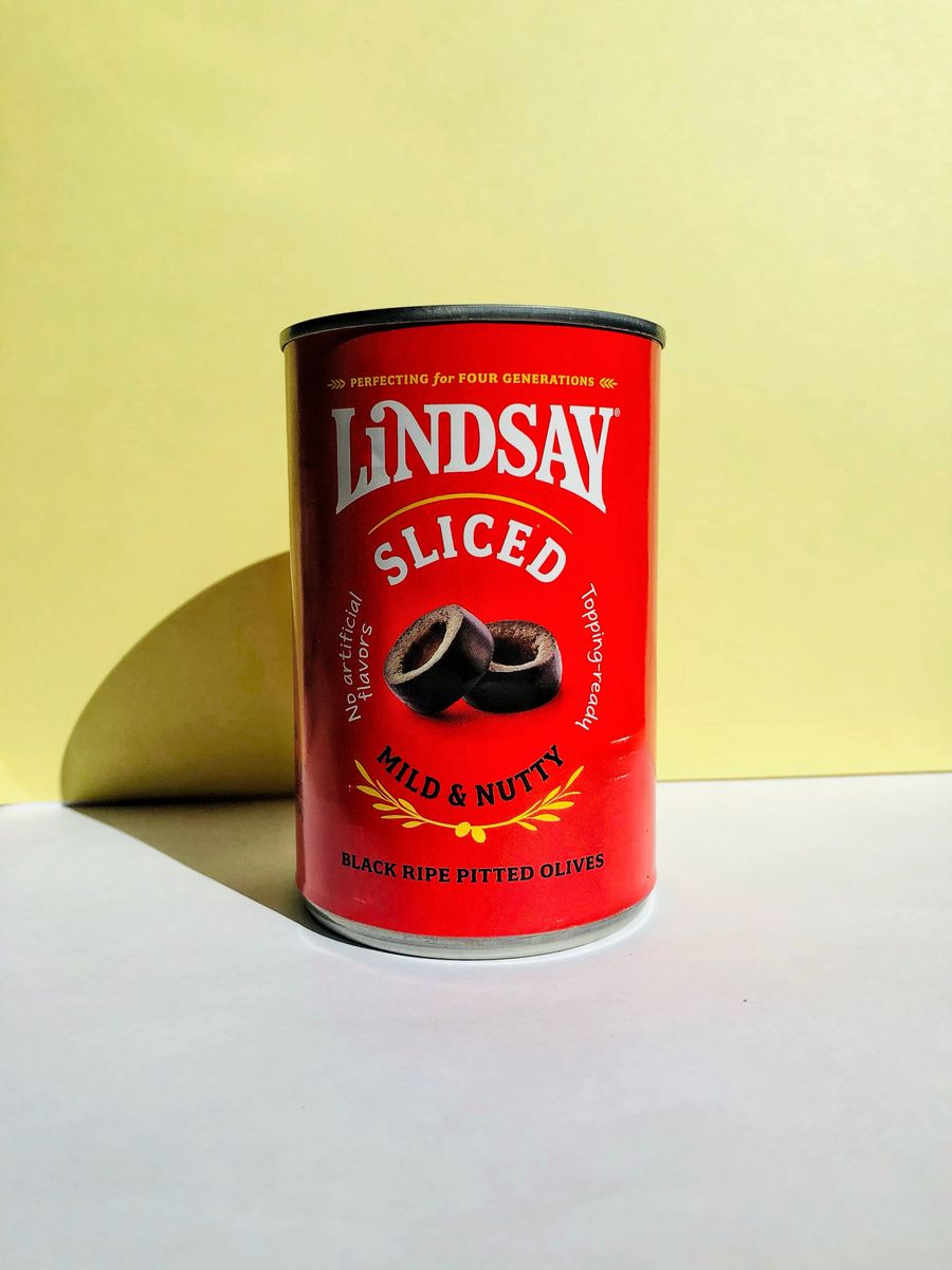 Photo of Lindsay Sliced Black Olives can against bright yellow backdrop, featuring bold text.