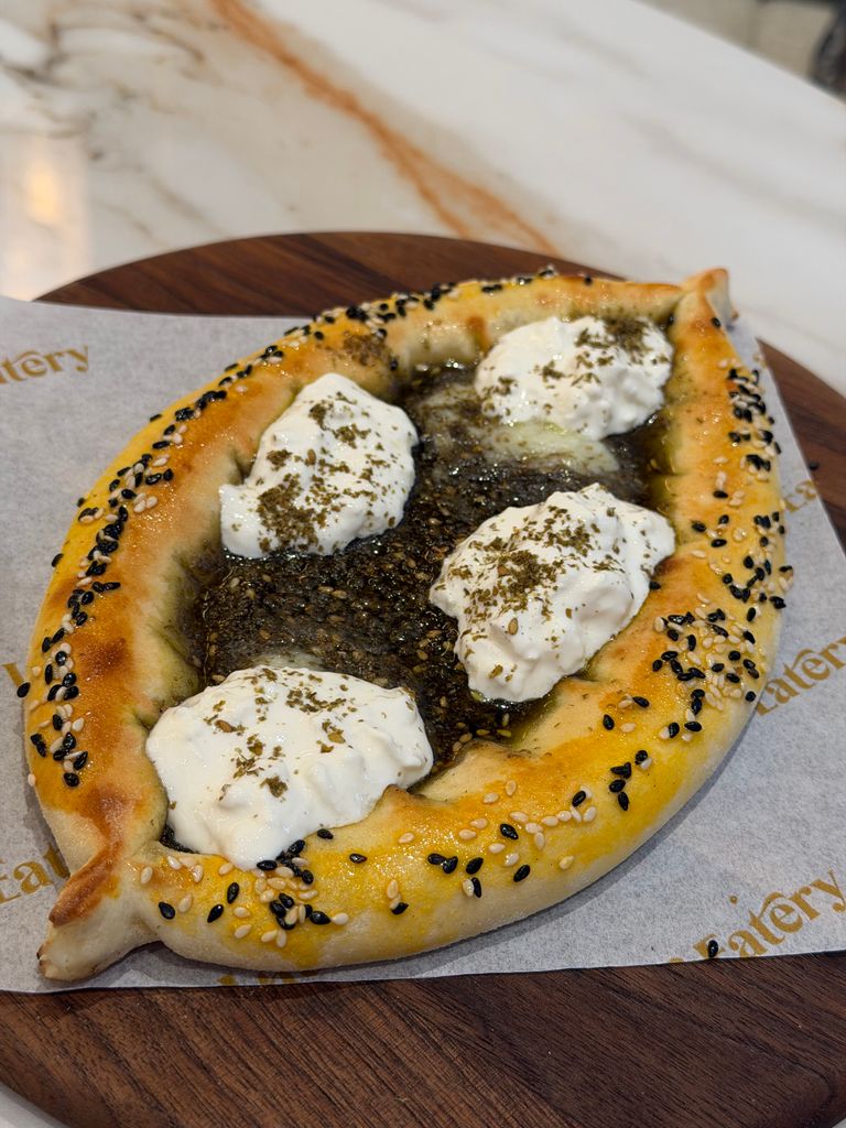 Savor this flavorful Zaatar bread topped with creamy cheese and herbs.