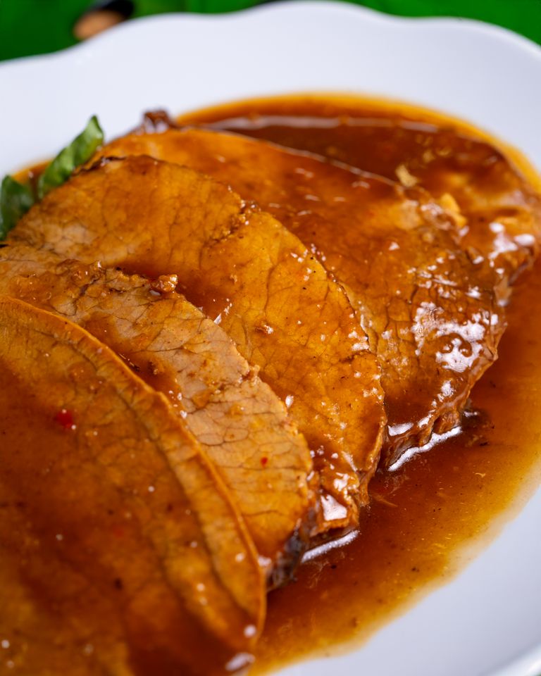 Succulent slices of roast beef covered in a rich, savory gravy.
