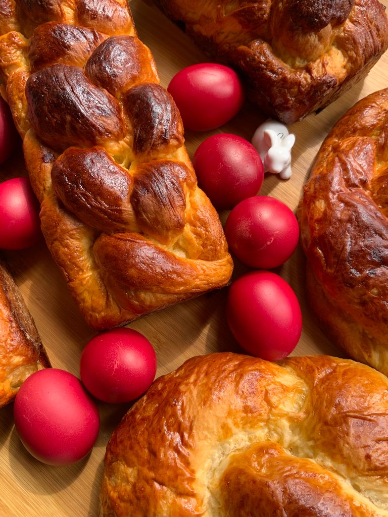 Traditional Easter bread with vibrant red eggs and a small white bunny figurine.