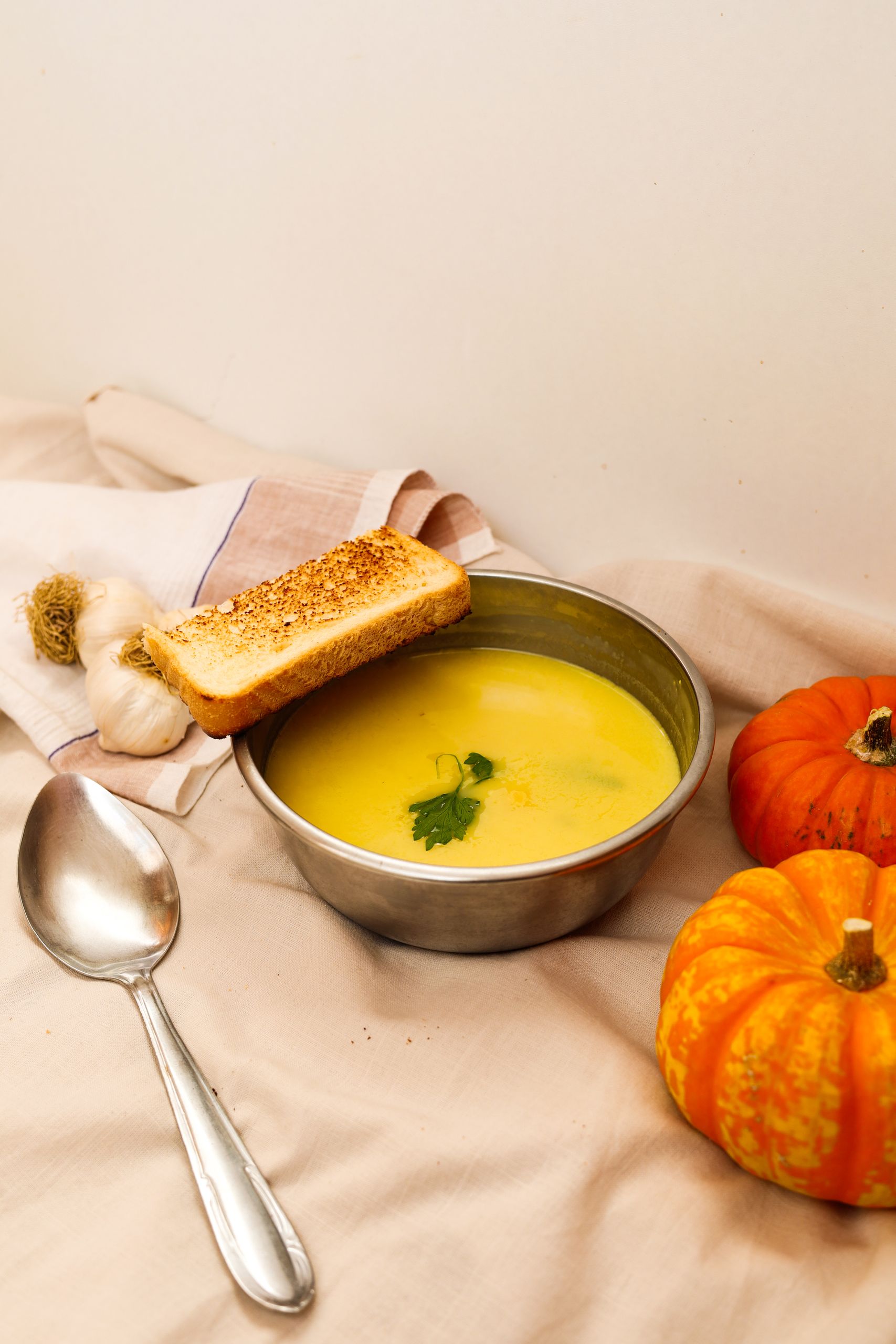 Warm pumpkin soup with toast and garlic, perfect for fall meals.
